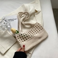 Schicke cremeweiße handgefertigte Häkeltasche mit hohlgestrickter Textur auf weißem Blazer - Gebrochenes Weiß