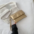 Elegante bolso de mano tipo sobre dorado con acabado metálico mate y correa de muñeca - Dorado