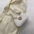 Borsa a tracolla trapuntata bianca con fibbia a timone dorata su un blazer beige - Bianco