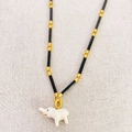 Bamboo chain necklace featuring a white enamel elephant pendant with gold accents - Black Chain + Beige Elephant