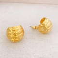 Macro detail van 18K vergulde bolvormige oorbellen met geborstelde textuur en sluiting - Goud