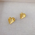 Detail of gold-plated irregular heart earrings with hammered texture on linen background - Gold