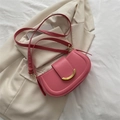Elegante roze halfronde zadeltas met een minimalistische gouden sluiting en schouderriem - Roze