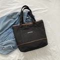Bolso tote minimalista de lona negra con ribete de cuero marrón y bolsillo frontal - Negro