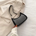 Borsa hobo nera con borchie argentate e forma a mezzaluna su sfondo di tessuto bianco - Nero