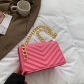 Pink quilted shoulder bag with golden chain strap on stylish fabric background - Pink