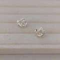 Elegante silberne Rosen-Ohrstecker mit strukturierten Blütenblättern auf beigem Tablett - Silber