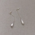 French minimalist silver brushed teardrop drop earrings on a rustic beige fabric background - Earrings