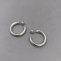 Detail von silbernen C-förmigen Creolen mit Kugelenden auf strukturiertem grauem Grund - Platin (Klein 2.5cm)