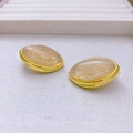 Vista detallada de pendientes ovalados vintage con marco dorado y textura mármol - Pendientes de Botón Ovalados Dorados / Pendientes de oro