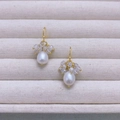Detailed close-up of water drop pearl earrings with faceted crystals on gold hooks - Clear White