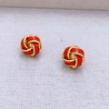 Makroaufnahme der roten Emaille- und goldfarbenen Herz-Knoten-Ohrstecker - Rot