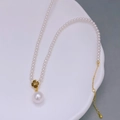 Elegante collana di perle bianche con ciondolo a fiore dorato su vassoio ceramica - Stile Sottile Ciondolo a Fiore
