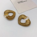 Orecchini a cerchio dorati con texture a corda intrecciata a spirale su sfondo grigio - Oro