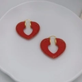 Dettaglio di orecchini a forma di cuore con filo intrecciato rosso e ganci dorati - Rosso
