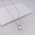Dettaglio macro della collana con ciondolo a sacchetto d'argento con finitura lucida - 48+5cm / Argento-Stile Sacchetto Portafortuna