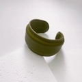 Detail of olive green leather cuff bracelet with visible stitching on a stone display - Width / Moss Green