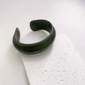 Close-up of dark green vintage leather cuff bracelet with detailed stitching on stone base - Narrow / Dark Green