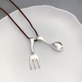 Silver spoon and fork pendant necklace with ebony beads on a white ceramic plate - Spoon And Fork Double Pendant Style