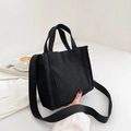 Minimalist black corduroy square handbag with crossbody strap and front pocket detail - Black