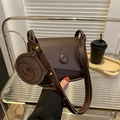 Dark brown saddle bag in lychee pattern leather featuring a cute bear coin purse pendant - Brown