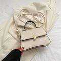Chic cream small square bag with unique flame-shaped gold buckle and black handle - White