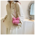 Detailed view of pink quilted rabbit ear crossbody bag worn by a model in a minimal setting - Pink