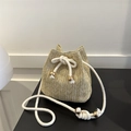 Beige woven straw bucket bag with white drawstring and metallic gold bead details - Khaki