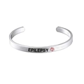 Macro detail of Epilepsy alert cuff bracelet in stainless steel with red medical star logo - Epilepsy Alert