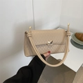 Beige quilted shoulder bag with gold metal clasp shown from a front-facing perspective - Khaki