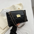 Classic black quilted crossbody bag featuring elegant gold chain strap and metal lock closure - Black