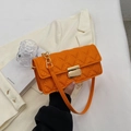 Quilted crossbody bag in vibrant orange with diamond stitching and gold buckle - Orange
