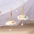Nahaufnahme bunter Regenschirm-Ohrringe mit Herzmuster und vergoldeten Haken - Herz-Muster-Stil