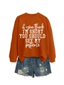 Flat lay of an orange crewneck sweatshirt with slogan and distressed denim shorts - Burnt Orange (White Font)