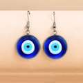 Ethno-Ohrhänger mit blauem Evil Eye und silbernen Fischhaken auf weichem orangefarbenem Grund - Silber