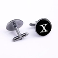 Macro view of gunmetal round cufflinks with black enamel inlay and white letter X design - Letter X