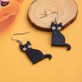Dettaglio di orecchini a gatto nero in acrilico con occhi gialli su base in legno - Gatto nero