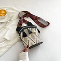 Ethnic woven bucket bag with geometric patterns and tassel details on a casual setup - Khaki