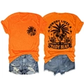 Flat lay of an orange t-shirt with a skeleton palm tree beach print and denim shorts - Orange (Black Graphic)