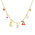 Gouden schakelketting met bedels zoals pokerkaart, kersen en strass letters A en K - Letter K Stijl