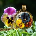 Gros plan d'un pendentif pensée en bronze sur fond de fleurs violettes naturelles - Pensée (Style 6)