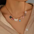 Close-up of golden necklace with colorful enamel pendants on a model neck - Sea Turtle