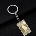 Close-up of silver cat tarot keychain featuring the XIV Temperance oil painting charm - TEMPERANCE