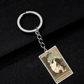 Macro detail of XII The Hanged Man cat tarot card pendant on stainless steel keychain - The Hanged Man