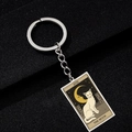 Macro shot of stainless steel Tarot keychain detail featuring The Moon cat oil painting - The Moon