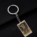 Detailed view of The Tower Tarot card keychain featuring a black cat and tower on metal - The Tower