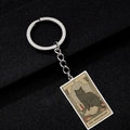 Detail of silver tarot keychain featuring The Hierophant black cat on a textured background - The Hierophant