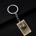Detail of The Hermit tarot keychain featuring a black cat design on polished metal - The Hermit
