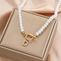 Detailed view of pearl necklace with gold-plated D-letter pendant and OT toggle clasp - Gold D