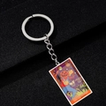 Close-up of Justice tarot card keychain with colorful Halloween pumpkin illustration - Justice